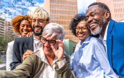 Mature businesswoman taking a selfie with colleagues outdoors