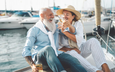 Senior couple toasting champagne on sailboat vacation - Happy el